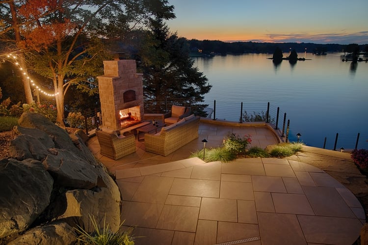A rustic fireplace clad in Indiana Limestone Berkshire™ thin veneer fits right into this wooded setting on Lake Shannon.