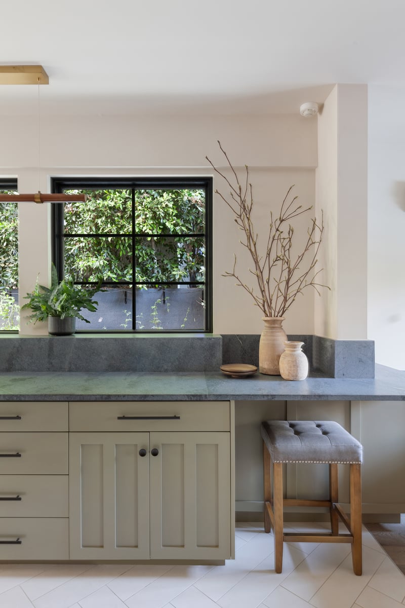 Muted Sage green cabinets and Alberene soapstone reflects natural light and creates a calming kitchen atmosphere